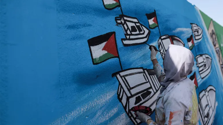 Palestinian artists create graffiti in support of Global Sumud Flotilla in Deir al-Balah